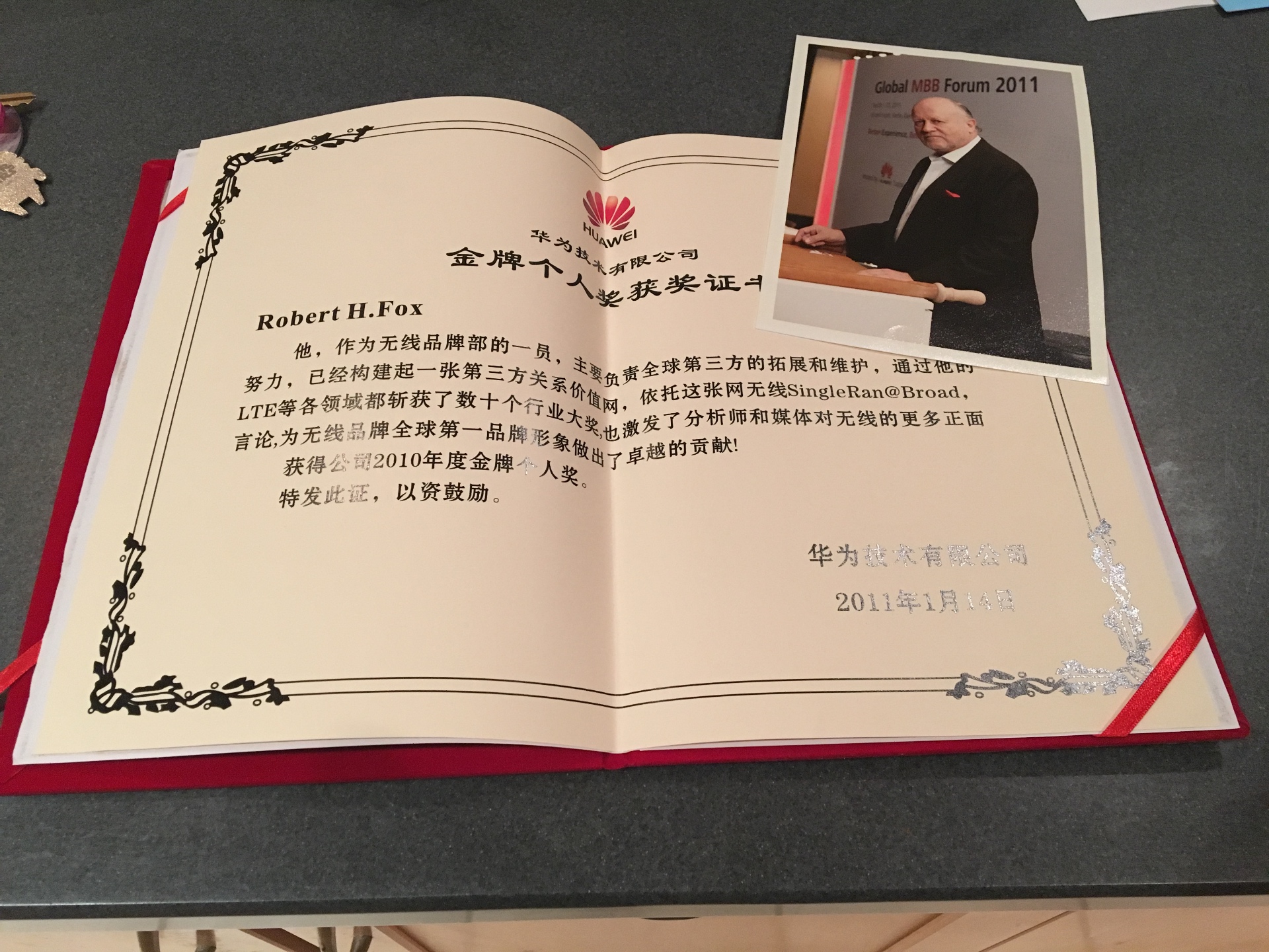 Huawei Gold Individual Award certificate, 2010, awarded to Robert H. Fox, alongside a photograph from the Global MBB Forum 2011 in Berlin.